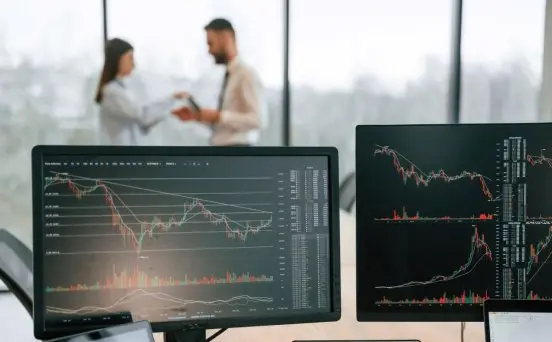 standing-behind-the-monitors-with-graphs-on-them-2024-02-21-01-31-30-utc