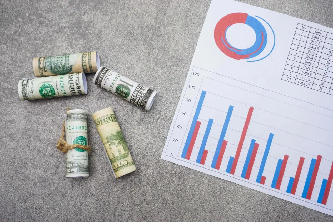flat-lay-of-rolled-dollar-bills-and-a-paper-with-c-2023-11-27-05-32-11-utc
